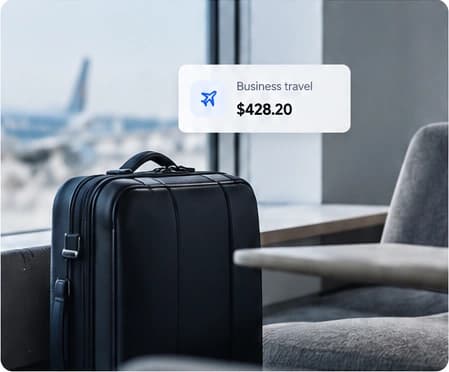 A carry-on suitcase beside an airport lounge window.